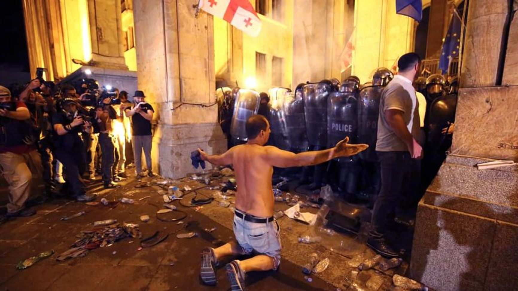 An opposition demonstrator stands in front of riot police outside Georgia’s parliament in Tbilisi.